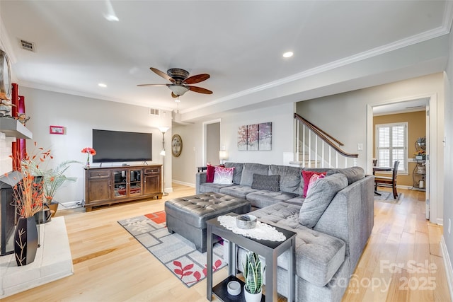 living room with light hardwood / wood-style flooring, ornamental molding, and ceiling fan