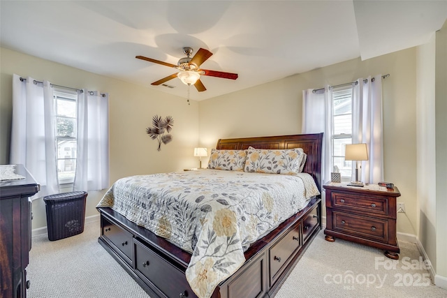 bedroom with multiple windows, light colored carpet, and ceiling fan