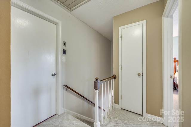 stairs featuring a textured ceiling