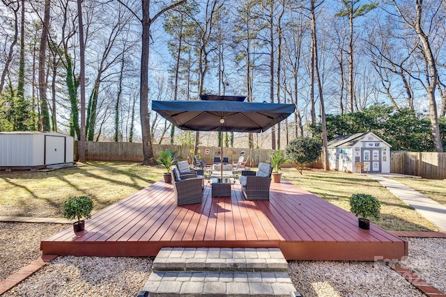 wooden terrace with a storage unit and a lawn