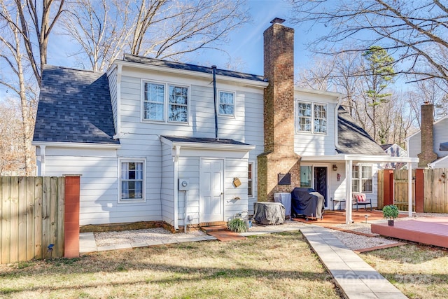 rear view of house featuring a wooden deck and a yard