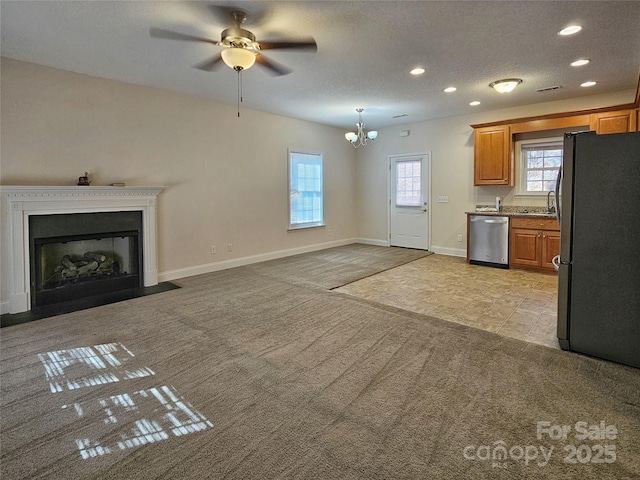 kitchen featuring hanging light fixtures, light carpet, a textured ceiling, appliances with stainless steel finishes, and ceiling fan