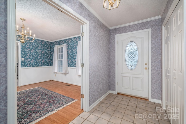 110 Robin Rd, Lincolnton, NC 28092 - foyer entrance with wallpapered walls, a textured ceiling, wainscoting, and a chandelier
