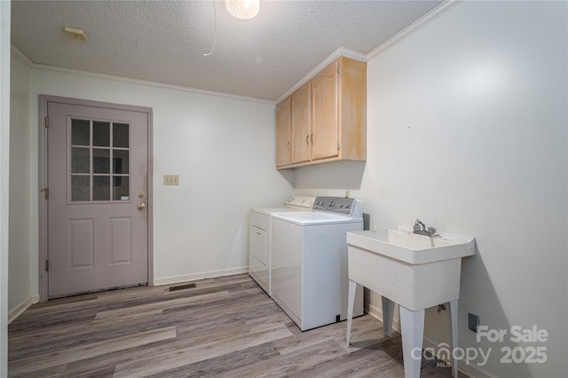 110 Robin Rd, Lincolnton, NC 28092 - washroom featuring light wood-type flooring, washer and clothes dryer, a textured ceiling, cabinet space, and baseboards