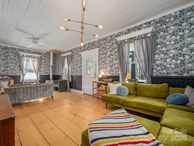 living room featuring ornamental molding, hardwood / wood-style floors, and ceiling fan with notable chandelier