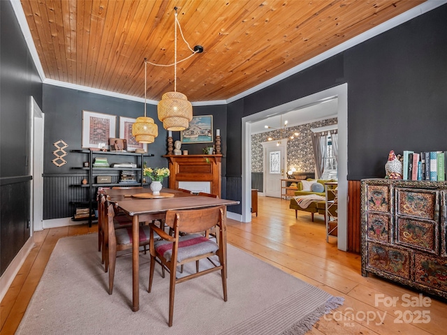 dining area featuring wooden ceiling, a chandelier, light wood-type flooring, and crown molding