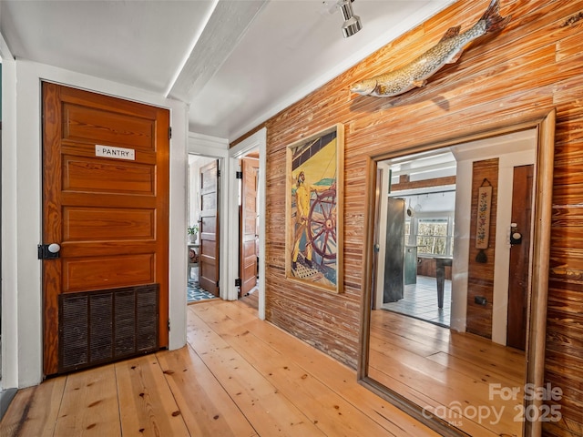 entryway featuring wooden walls and light hardwood / wood-style floors