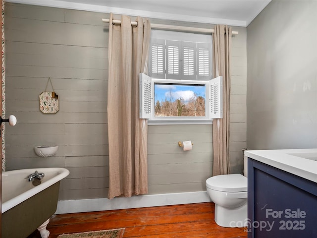 bathroom featuring a tub to relax in, vanity, toilet, and hardwood / wood-style floors