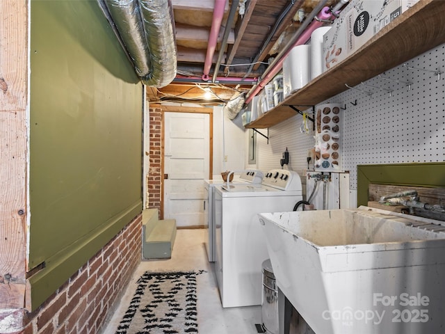 laundry area with sink, washer and dryer, and a workshop area