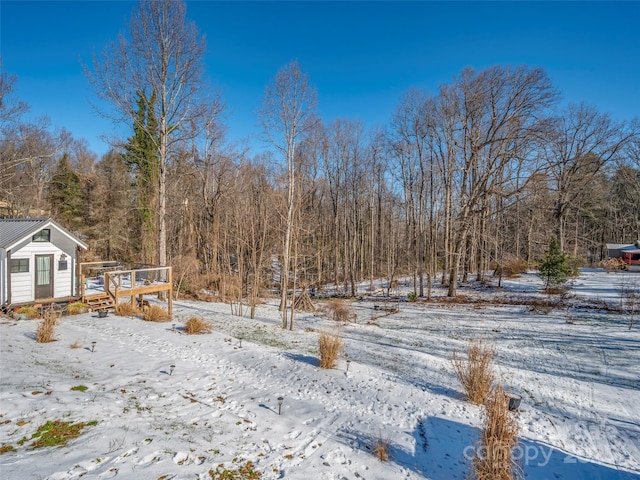 yard layered in snow featuring a wooden deck