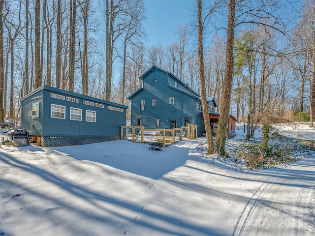 view of snow covered back of property