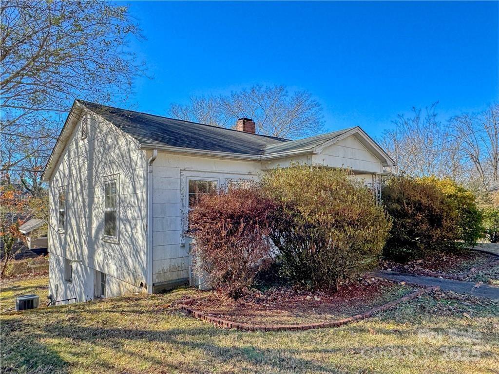 view of side of home with a yard