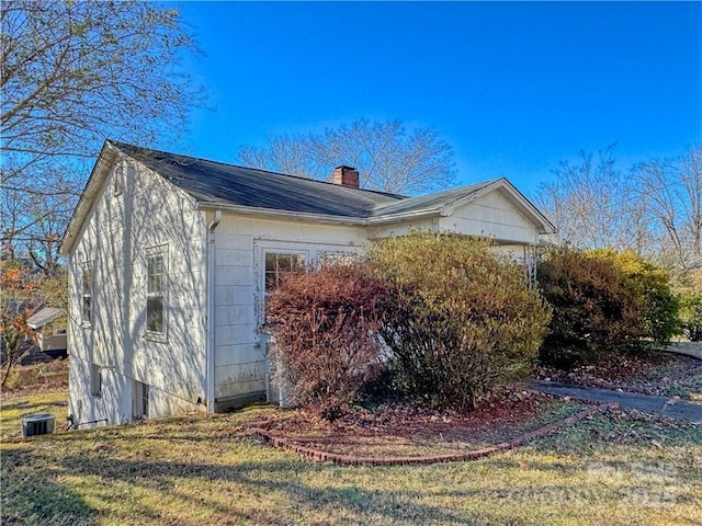 view of side of home with a yard