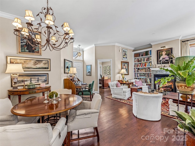 dining area featuring built in features, ornamental molding, a chandelier, and dark hardwood / wood-style floors