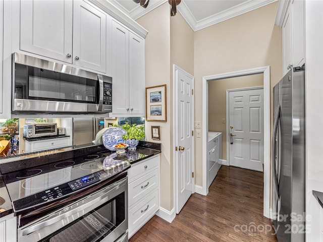 kitchen featuring dark wood-type flooring, white cabinets, appliances with stainless steel finishes, and ornamental molding