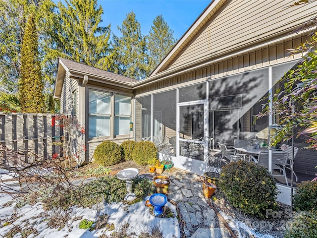 view of property exterior with a sunroom