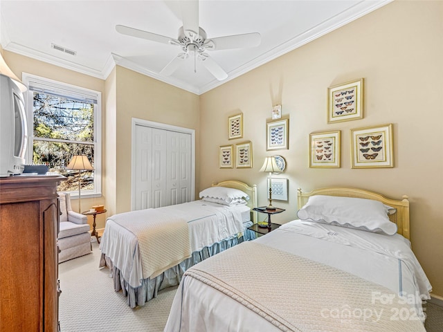 bedroom with ceiling fan, light colored carpet, a closet, and ornamental molding