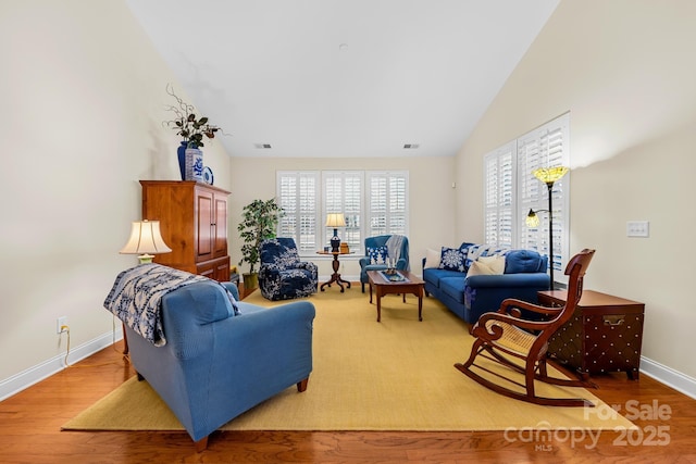 living room featuring vaulted ceiling and hardwood / wood-style floors