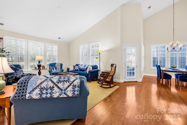 living room featuring a chandelier, hardwood / wood-style floors, and high vaulted ceiling