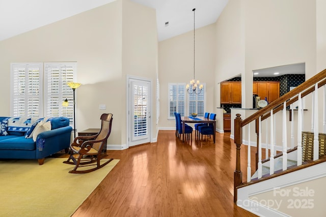 living room featuring hardwood / wood-style floors, an inviting chandelier, high vaulted ceiling, and a healthy amount of sunlight