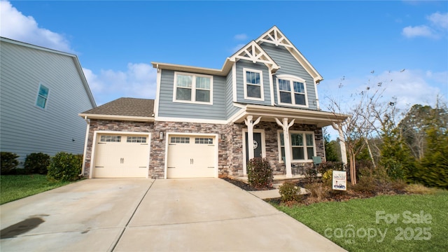 craftsman inspired home featuring covered porch, a garage, and a front yard