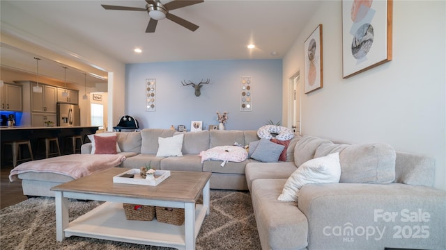 living room featuring ceiling fan and dark hardwood / wood-style flooring