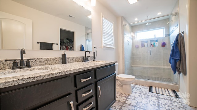 bathroom with vanity, toilet, and a shower with door