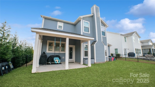 rear view of property featuring a patio area and a yard