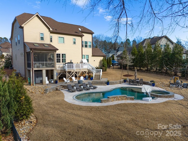 rear view of property featuring a deck, stairway, a patio area, and a sunroom