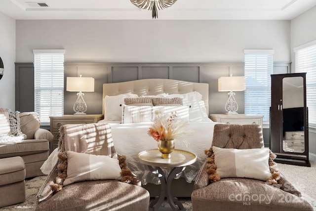 bedroom featuring multiple windows, carpet flooring, and visible vents