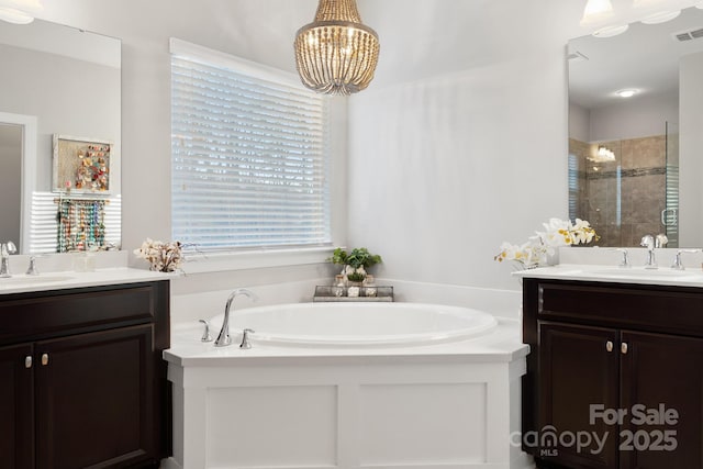 bathroom with a garden tub, a shower stall, and a sink