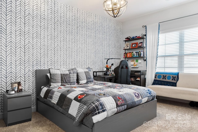 bedroom with an accent wall and a notable chandelier