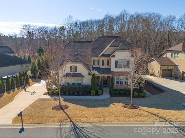 view of front of home with a garage, concrete driveway, metal roof, a standing seam roof, and board and batten siding