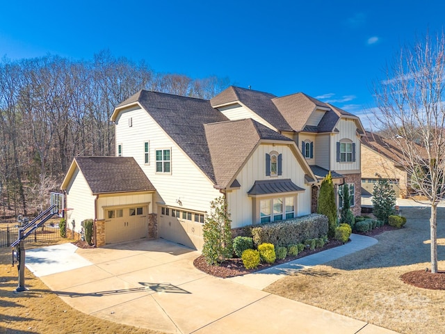 view of front of property with a shingled roof, fence, concrete driveway, board and batten siding, and a standing seam roof