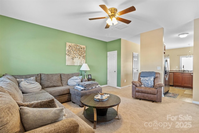 carpeted living room with ceiling fan and sink