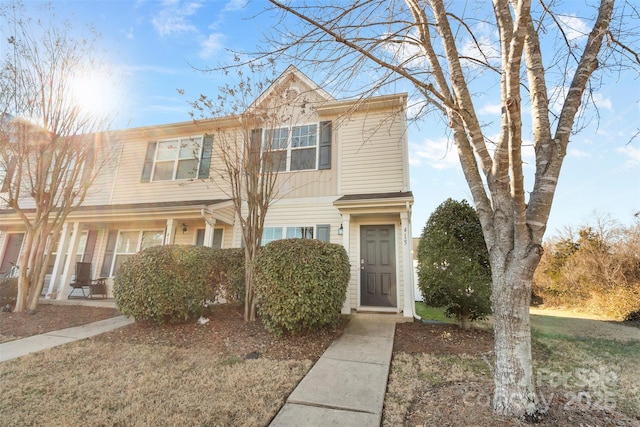 townhome / multi-family property featuring a front lawn