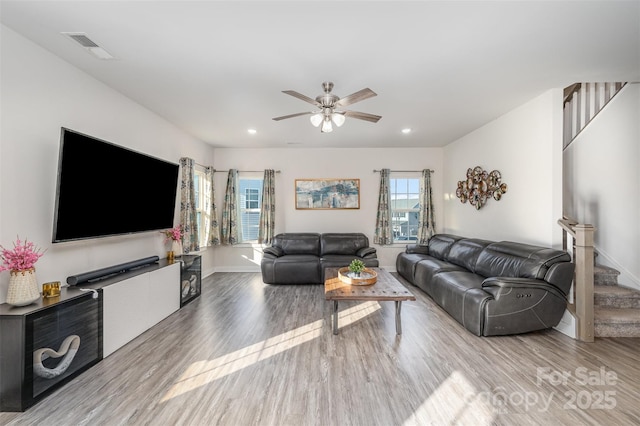 living room featuring ceiling fan and light hardwood / wood-style flooring