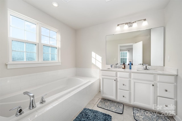 bathroom with vanity, a relaxing tiled tub, and tile patterned floors