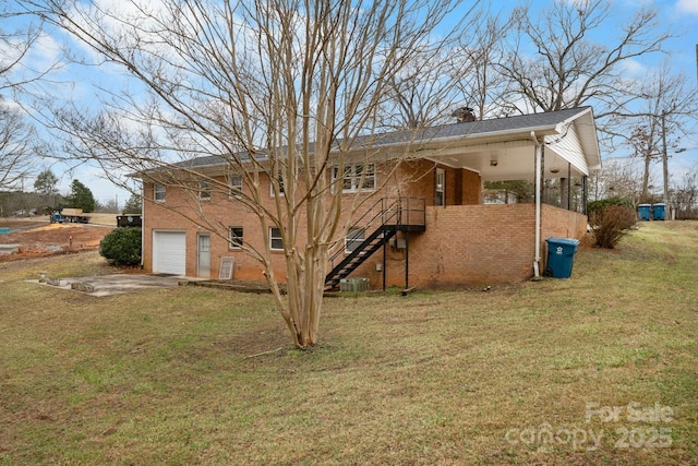 rear view of house featuring a yard, a garage, and central air condition unit