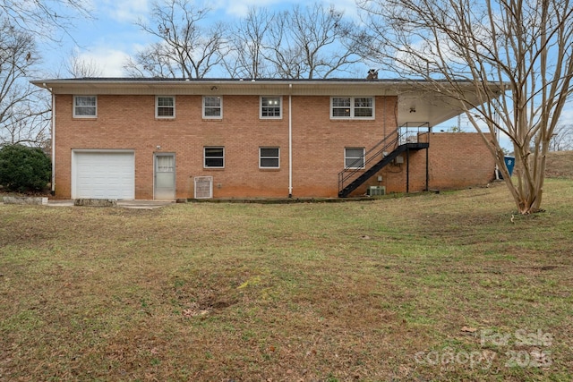 back of house with a garage, central AC unit, and a lawn