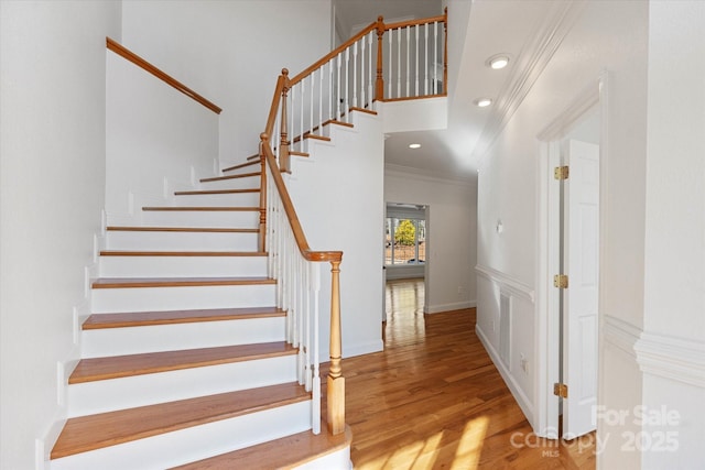 stairs featuring hardwood / wood-style flooring and ornamental molding