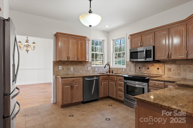 kitchen featuring decorative light fixtures, a notable chandelier, sink, stainless steel appliances, and light tile patterned floors