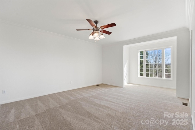 carpeted empty room featuring ceiling fan and crown molding