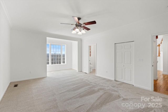 empty room with ceiling fan, ornamental molding, and light colored carpet