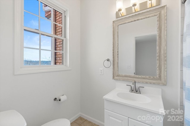 bathroom with toilet, vanity, and tile patterned floors