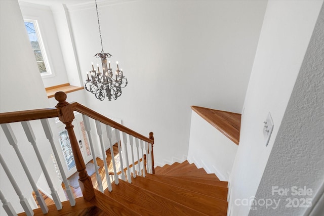 stairway featuring a notable chandelier and hardwood / wood-style flooring