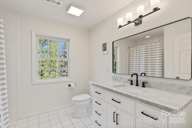 bathroom with tile patterned floors, toilet, vanity, and walk in shower