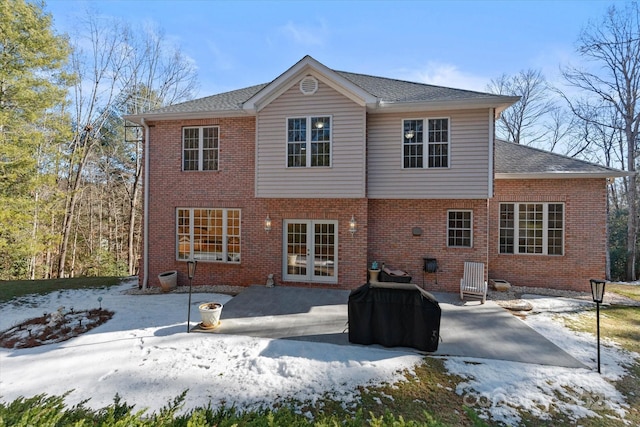 snow covered property with a patio area