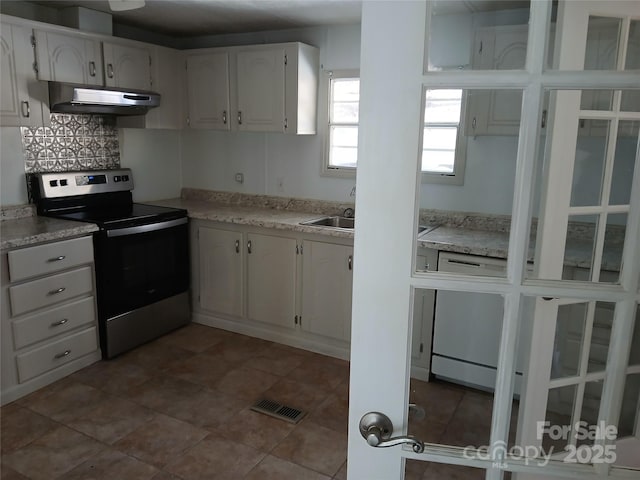 kitchen featuring white cabinetry, stainless steel electric range oven, sink, and backsplash