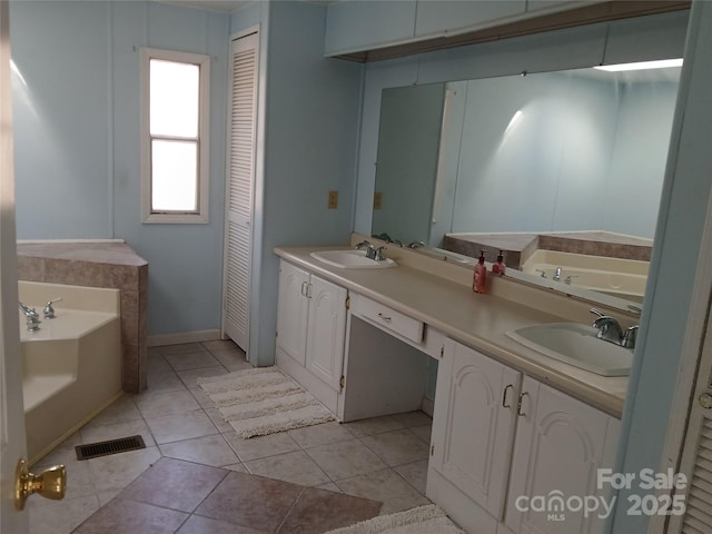 bathroom with vanity, a bath, and tile patterned flooring